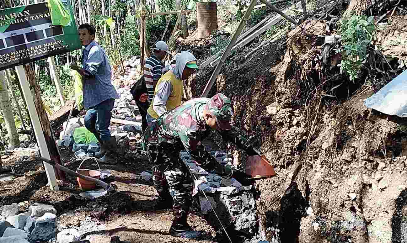 TNI dan warga bergotong royong di lokasi TMMD Kodim 0818. (Foto: PHOTO TI NETWORK) 