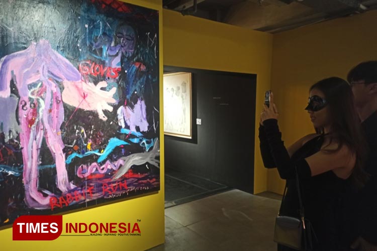 Pengunjung pesta topeng saat mengabadikan karya Khadir dalam sebuah pameran lukis dan instalasi bertajuk Masquerade di WIN Hotel Surabaya, Sabtu (9/9/2023) malam.(Foto : Lely Yuana/TIMES Indonesia)