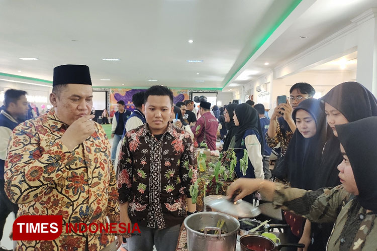 Rektor Unisla Abdul Ghofur saat mengunjungi stand peserta dan mencicipi produk UMKM yang dipamerkan peserta KKN Unisla, Selasa (12/9/2023). (Foto: Moch. Nuril Huda/ TIMES Indonesia)