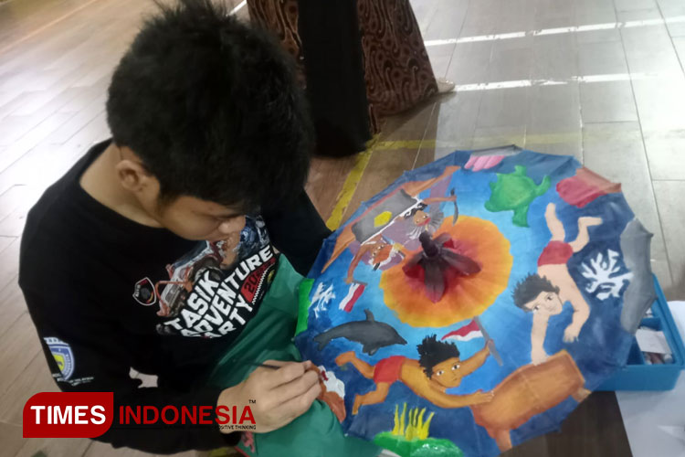 Dua peserta Gerentes Painting Competition saat melukis pada payung geulis dengan tema Nautika Nusantara di Kampus SMAN I Tasikmalaya, Kamis (14/9/2023) (FOTO: Harniwan Obech/TIMES Indonesia)