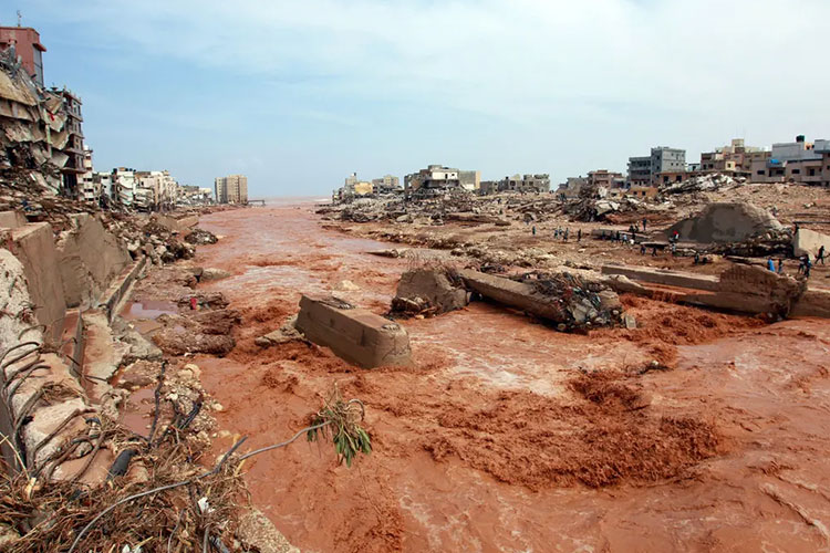 Orang-orang Libya melihat dampak kerusakan parah seperti bangunan hancur karena banjir bandang, Jum’at (15/09/2023) (FOTO: AFP/Getty Images)