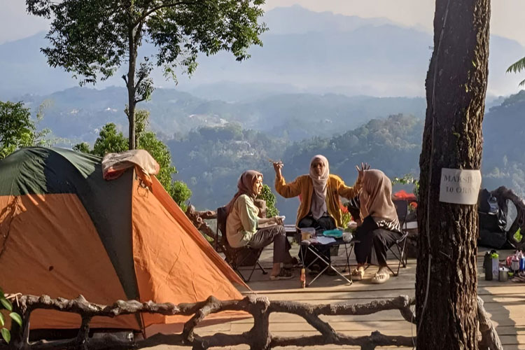 Pengunjung tengah camping sambil menikmati pesona alam Batu Nyongclo Majalengka. (FOTO: IG wisatahutanpinus_batu_nyongclo)