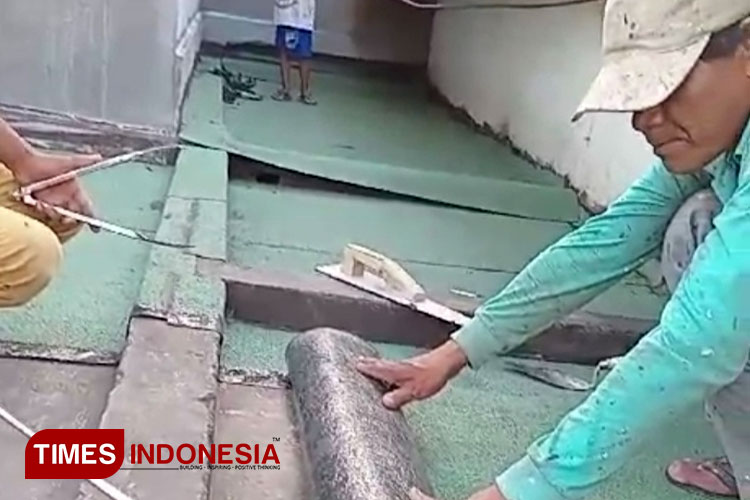 Proses pemasangan membran waterproofing untuk mengatasi solusi kebocoran jelang musim hujan. (Foto: Susi/TIMES Indonesia) 