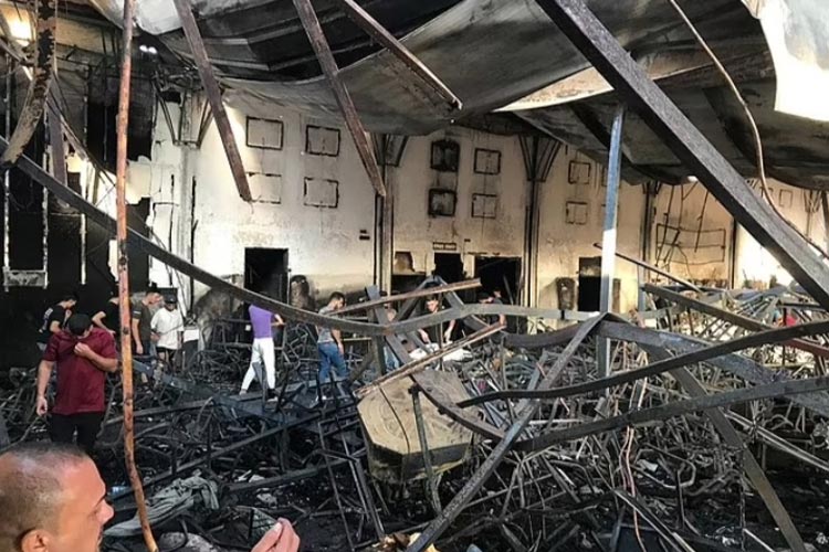 Bagian dari aula yang terbuat dari bahan mudah terbakar menyisakan rangka besi yang menumpuk setelah ambruk dan menimpa para tamu. (FOTO: Daily Mail/Anadolu Agency via Getty Image)
