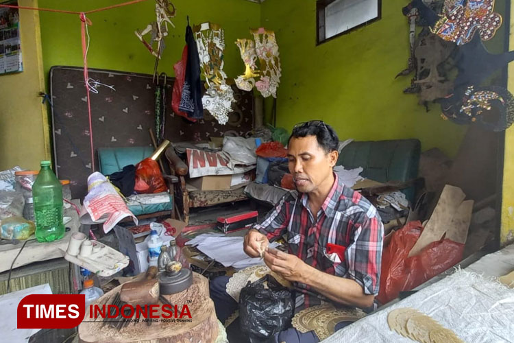 Pengrajin wayang kulit yang beralamat tinggal di Jalan Yos Sudarso, Lingkungan Sukowidi, Kelurahan Klatak, Kecamatan Kalipuro, Banyuwangi, Eko Susanto sedang menjelaskan detail pahatan. (FOTO : Anggara Cahya /TIMES Indonesia)