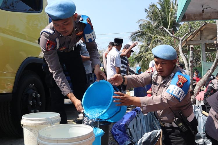 Anggota Polri tengah membagikan air bersih kepada warga yang terdampak kekeringan (FOTO: dok Humas Polres Magelang Kota)