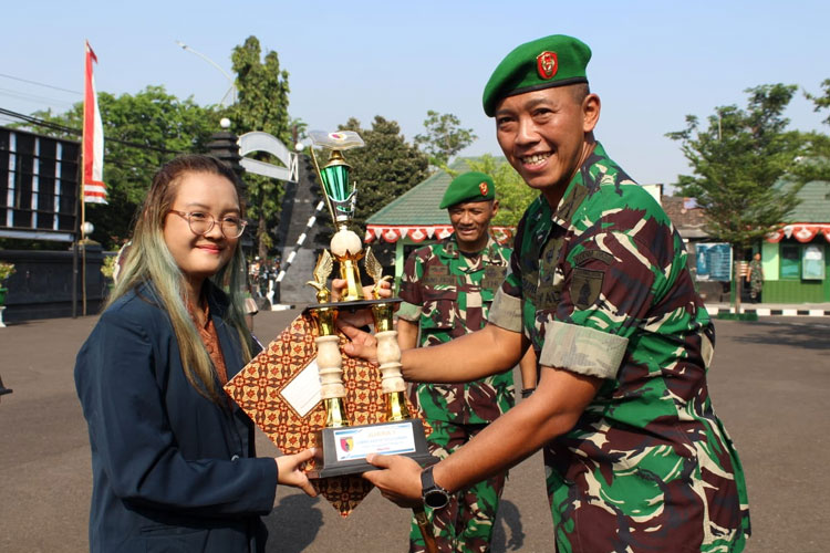 Komandan Kodim 0830/Surabaya Utara Letkol Inf Dharmawan Setyo Nugroho, S.I.P. menyerahkan piala kepada Arifiah Putri, mahasiswa Universitas Brawijaya yang berhasil memenangkan lomba karya tulis ilmiah, Jumat (6/10/2023).(Dok.Kodim 0830/Surabaya)