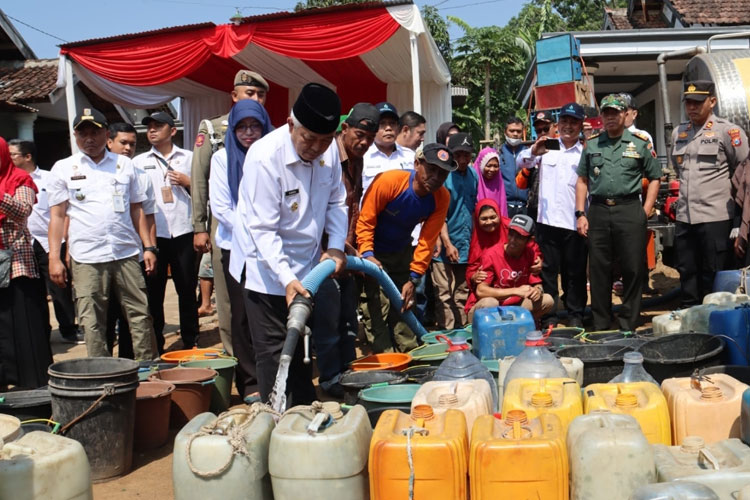Bupati Malang Sanusi Ketika mendistribusikan air bersih kepada warga. (Foto: Prokopim Kabupaten Malang).