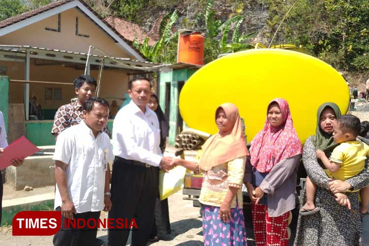 Kepala Sekolah SMK Negeri 1 Pundong Bantul menyerahkan bantuan air bersih kepada warga Gumbeng Giripurwo Purwosari. (Foto: Edis/TIMES Indonesia)