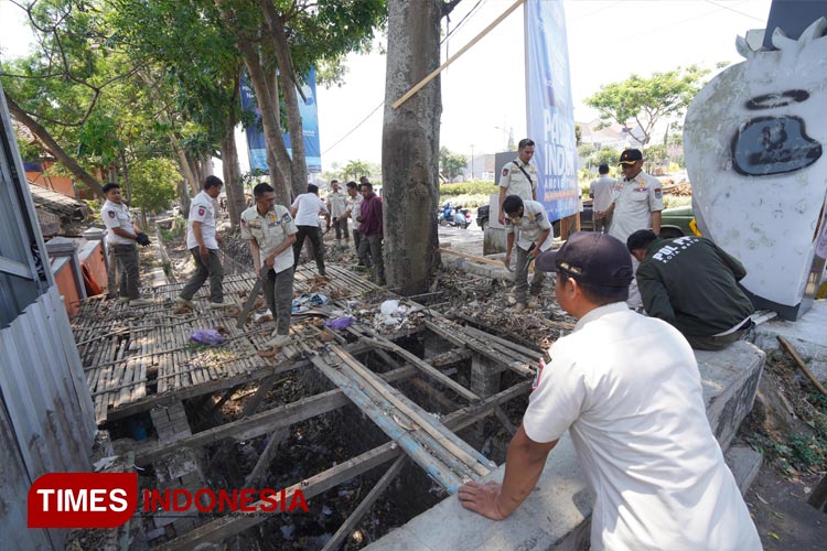 Pj Wali Kota Batu membersihkan sisa lapak pasar relokasi. (Muhammad Dhani Rahman/TIMES Indonesia)