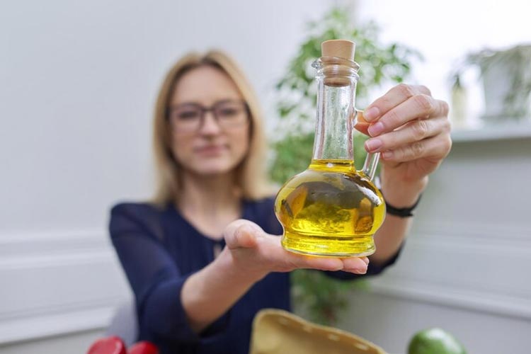 Seorang wanita memegang sebotol minyak zaitun di tangannya. (Foto: vh-studio/Freepik)