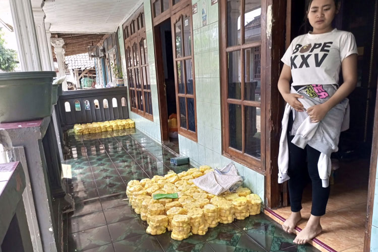 Tampak warga Kenduruan perajin Tape, sedang mengemas produksi tape yang akan dikirim 2 hari kemudian, didepan rumahnya. (Foto: bet)