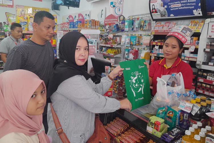Salah satu petugas Alfamart di Blitar memberikan tas go green kepada pelanggan. (Foto: Alfamart for TIMES Indonesia)