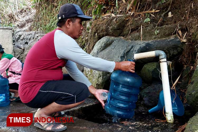 Warga asal Dusun Kertosono, Desa Parijatah Kulon, Kecamatan Srono, Banyuwangi sedang mengambil sumber mata air Pekiringan. (FOTO : Anggara Cahya /TIMES Indonesia)