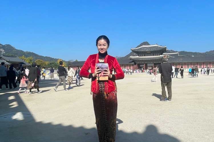 Izabelle Kiara Kurniawan dengan bangga menunjukkan novel karyanya dengan latar belakang Gyeongbokgung Palace, Korea Selatan. (FOTO: Izabelle Kiara Kurniawan for TIMES Indonesia)
