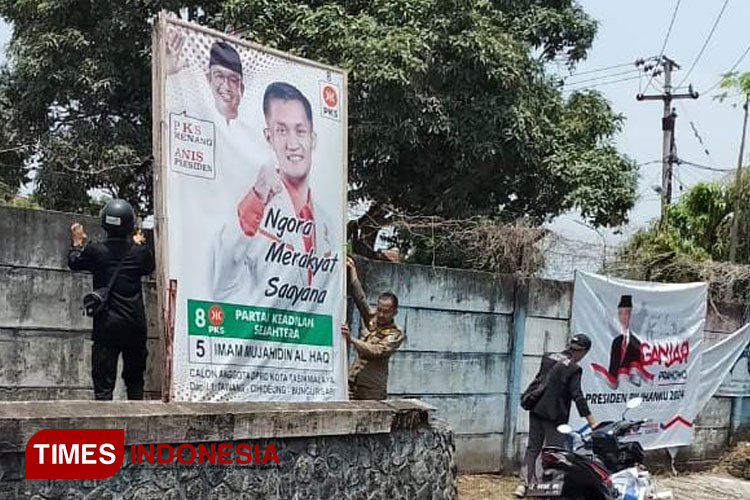 Sejumlah personel Bawaslu Kota Tasikmalaya menertibkan beberapa Baliho di kawasan jalan seputar stasiun Kota Tasikmalaya, Jawa Barat, Rabu (8/11/2023). (FOTO: Harniwan Obech/TIMES Indonesia)