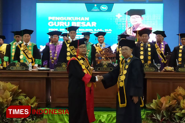 Pengukuhan Prof. Dr. H. Nur Sholikin, S.Ag., M.H. sebagai guru besar dalam bidang ilmu sosiologi hukum Islam (kiri) oleh Rektor UIN KHAS Jember, Prof. Hepni (kanan). (Foto: Siti Nur Faizah/TIMES Indonesia) 