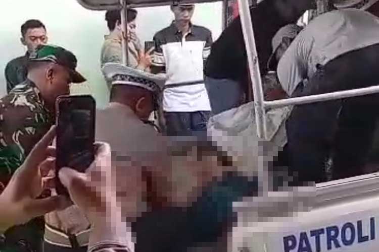 Petugas kepolisian saat mengevakuasi tubuh korban menuju RSUD Ngudi Waluyo, Wlingi.
