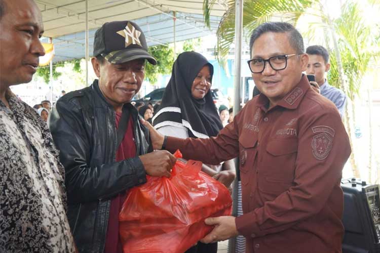 Wali Kota Gorontalo, Marten Taha saat menyerahkan bantuan bahan pangan pokok kepada masyarakat penerima manfaat. (Foto: Humas Pemkot Gorontalo for TIMES Indonesia)