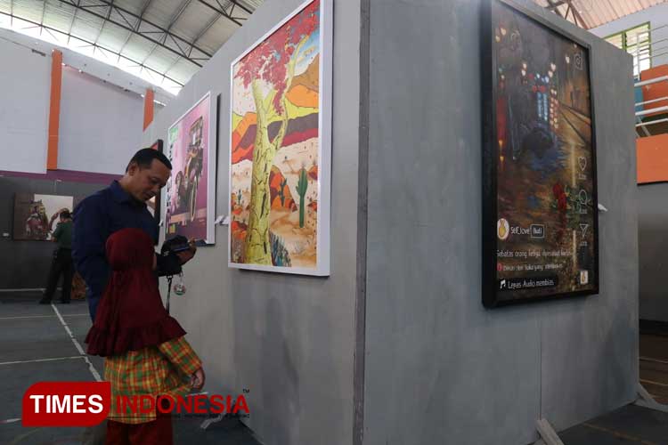 Para pengunjung saat melihat pameran lukisan yang diselenggarakan oleh KOPI Jombang di GOR Merdeka Jombang, Minggu (10/12/2023). (FOTO: Rohmadi/TIMES Indonesia)