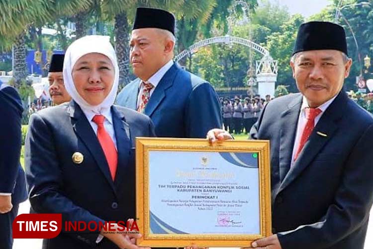 Gubernur Jawa Timur, Khofifah Indar Parawansa menyerahkan penghargaan peringkat pertama tim terpadu Banyuwangi. (FOTO: Fazar Dimas/TIMES Indonesia)