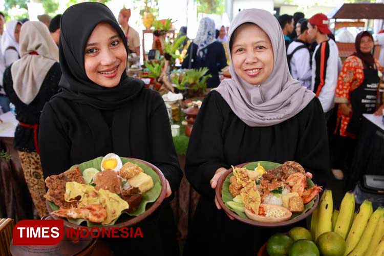 Two lovely ladies holding pecel rawon on their hand. (Photo: Laila Yasmin/TIMES Indonesia)