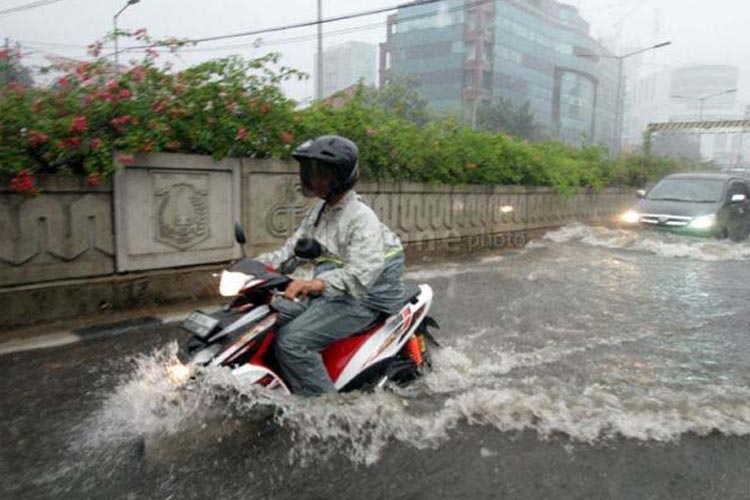 Ilustrasi - Berkendara pada saat hujan. (FOTO: pusatkrisis.kemkes.go.id)