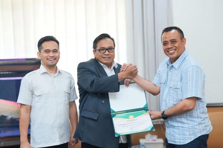 Rektor Unissula Semarang Prof Gunarto (tengah) menyerahkan surat keputusan (SK) doktor honoris causa kepada Kombes Pol Agus Tri Heriyanto, di Kampus Unissula, Semarang, Sabtu (13/1/2024). (FOTO: ANTARA/HO-Unissula)