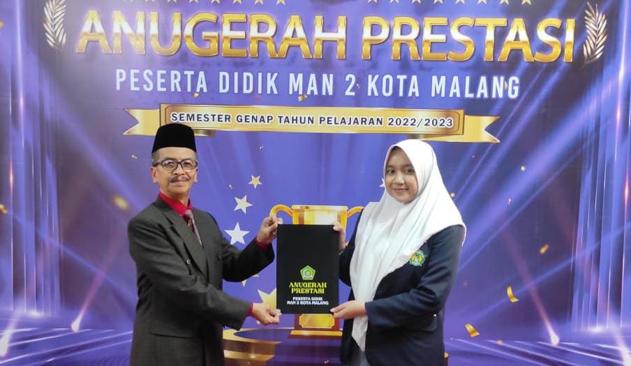 Kepala MAN 2 Kota Malang Dr. H. Samsudin, M.Pd., memberi ijazah dan penghargaan secara simbolis pada salah satu siswi. (Foto: MAN 2 for TIMES Indonesia) 