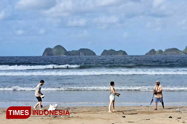 Wisatawan mancanegara yang sedang turut membersihkan pantai Pulau Merah. (Foto: Anggara Cahya/TIMES Indonesia)