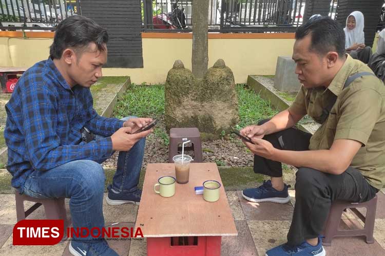 Tampak pengunjung nongkrong dengan latar belakang benda megalitik batu kenong (FOTO: Moh Bahri/TIMES Indonesia) 