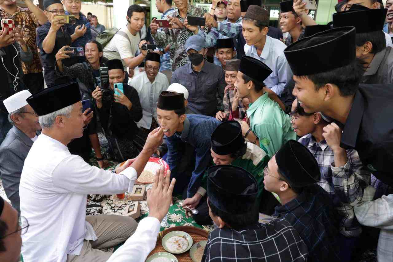 Ganjar menyuapi seorang santri dengan bubur merah. (Foto: TPN) 