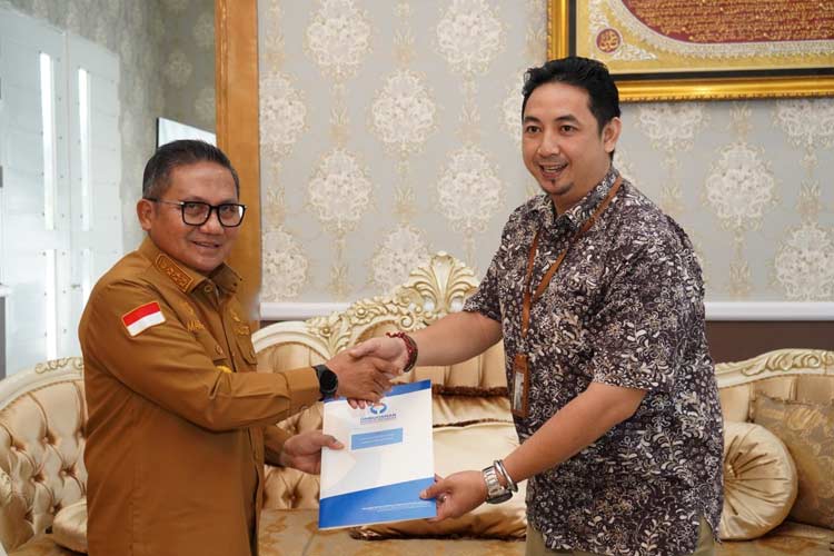 Kepala Ombudsman RI Perwakilan Gorontalo, Wahyudin Mamonto saat menyerah hasil penilaian kepada Wali Kota Gorontalo, Marten Taha. (Foto: Humas Pemkot Gorontalo) 