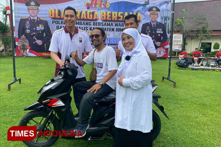 Zainul Arifin Wartawan Anggota PWI Jombang senyum bahagia saat menerima Motor hadiah jalan sehat dalam rangka Hari Pers Nasional yang diselenggarakan oleh Polres Jombang di Lapangan Mapolres Jombang, Rabu (7/2/2024). (FOTO: Rohmadi/TIMES Indonesia)