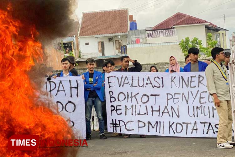 Sejumlah mahasiswa dari PMII Kota Tasikmalaya membentangkan spanduk di depan Kantor KPU Kota Tasikmalaya, Rabu (7/2/2024) siang. (FOTO: Harniwan Obech/TIMES Indonesia)