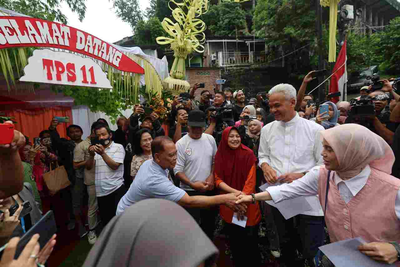 Ganjar dan istri menyapa warga usai mencoblos di TPS 11 Lempongsari, Kota Semarang. (Foto: TPN)