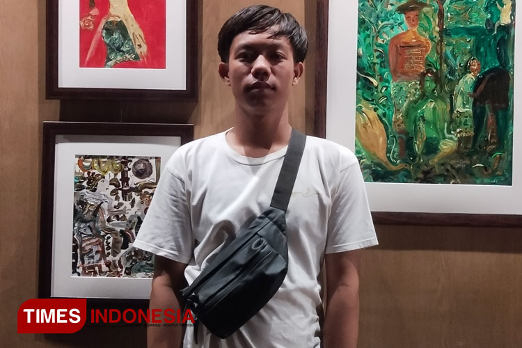 Dendi, salah satu seniman muda berbakat berfoto dengan hasil karya yang dipamerkan di Artspace Artotel Sanur Bali. (FOTO: Susi/TIMES Indonesia)
