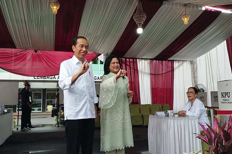 Presiden Jokowi dan Ibu Iriana menunjukkan jari bertinta usai nyoblos di TPS 10, Gambir, Jakarta Pusat, Rabu (14/2/2024). (Foto: RRI/Pradipta Rahadi)