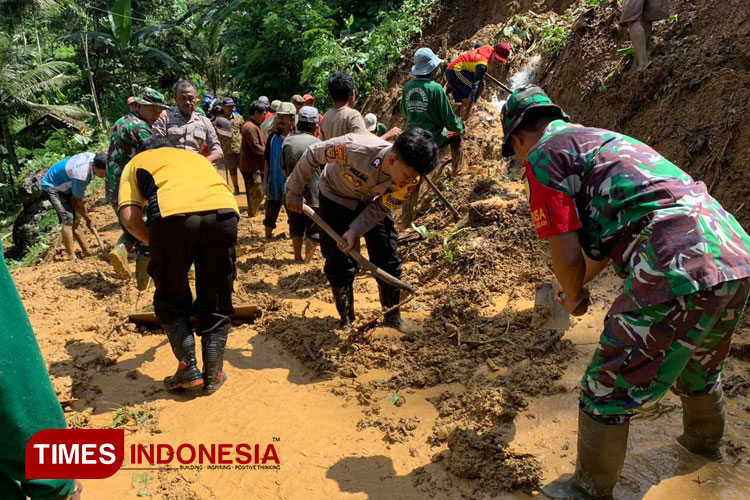 Anggota Polres Pacitan bersama TNI dan masyarakat membantu membersihkan sedimen tanah longsor yang menimpa rumah warga. (FOTO: Tomas for TIMES Indonesia)