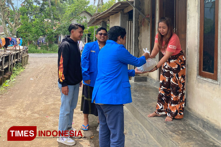 Aktivis mahasiswa PMII Kabupaten Bondowoso memberikan bantuan sembako kepada warga yang membutuhkan (FOTO: Moh Bahri/TIMES Indonesia) 