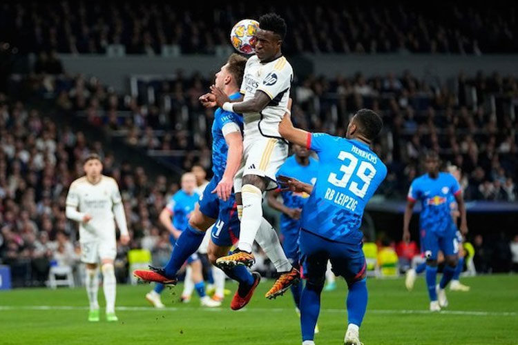 Duel Vinicius Junior dan Willi Orban dalam laga 16 besar Liga Champions antara Real Madrid vs RB Leipzig, Kamis (7/3/2024). (Foto: AP Photo/Manu Fernandez)