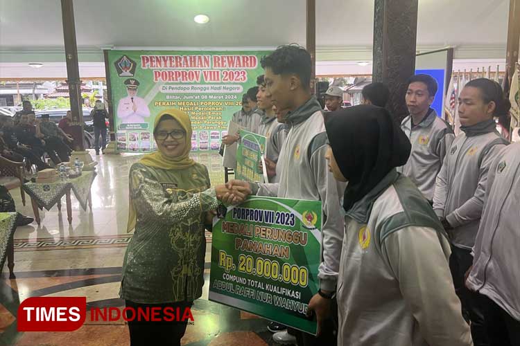 Bupati Blitar, Rini Syarifah atau Mak Rini, menyerahkan penghargaan kepada para atlet kontingen Kabupaten Blitar. (Foto: Zainal Arifin/TIMES Indonesia)