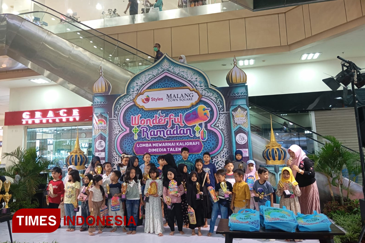 Peserta lomba mewarnai kaligrafi di media talenan berfoto bersama menunjukkan hasil karyanya (FOTO: Dinda Amorita Thafifa Zahro/TIMES Indonesia).