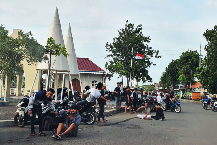 Para anak muda yang sedang asyik ngabuburit sambil menunggu mengambil momen atau angle yang menarik untuk di foto di kawasan Pelabuhan Kota Pasuruan. (FOTO: Robert)