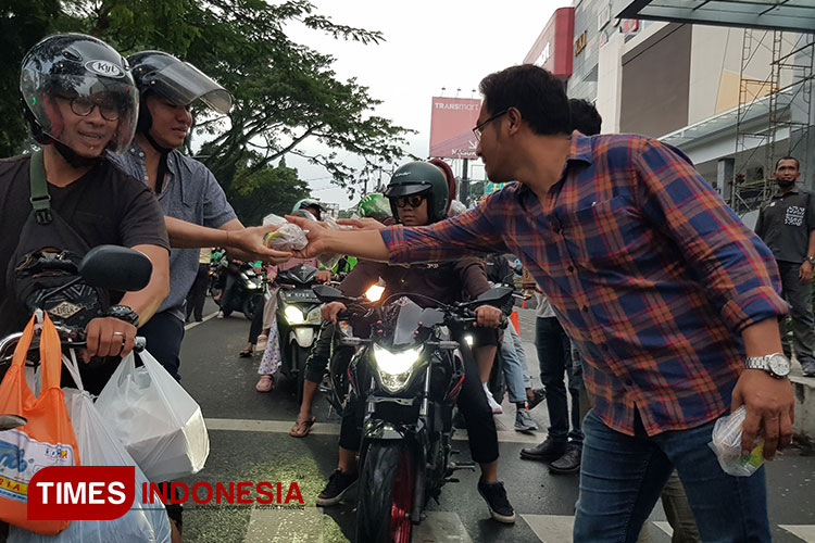 Bagi-bagi takjil gratis untuk pengguna jalan dan masyarakat yang dilakukan  Matos pada Kamis (21/3/2024). (Foto: Achmad Fikyansyah/TIMES Indonesia) 