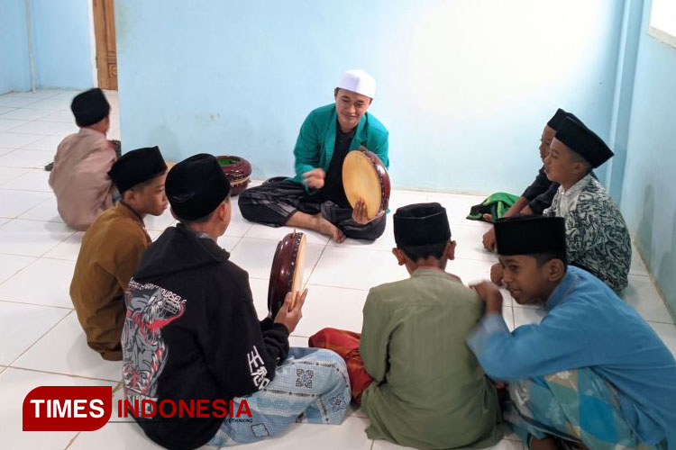 Pembelajaran memainkan alat rebana oleh Anggota BSO Lintang Songo kepada santri TPQ An-Nur Desa Blandit. (FOTO: AJP TIMES Indonesia)