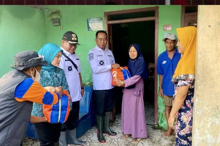Pj Bupati Probolinggo saat memberikan bantuan pada salah satu korban terdampak banjir. (Foto: Kominfo for TIMES Indonesia)