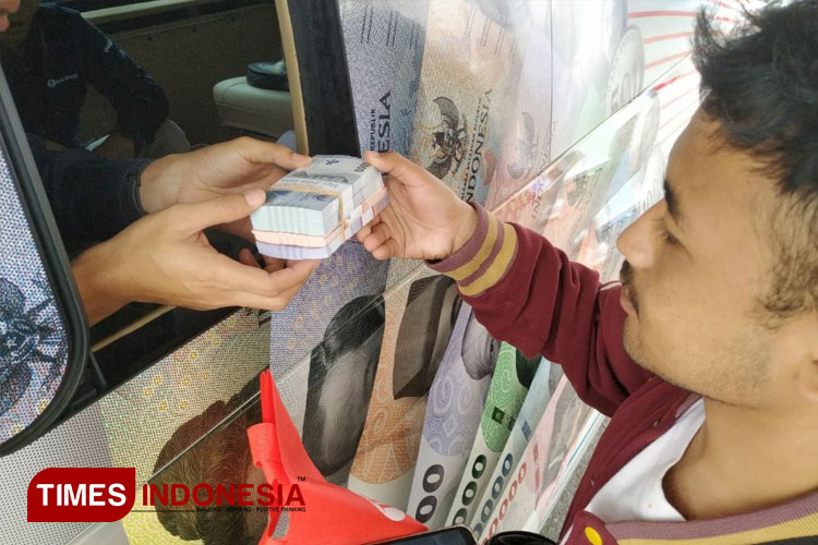 Salah satu masyarakat saat melakukan penukaran uang baru (FOTO: Yobby/TIMES Indonesia) 