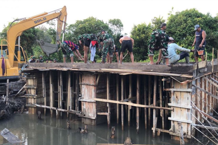 Satgas TMMD bersama Warga Membuat jembatan, Gotong Royong Antara Satgas TMMD dengan Warga. (FOTO: AJP TIMES Indonesia)