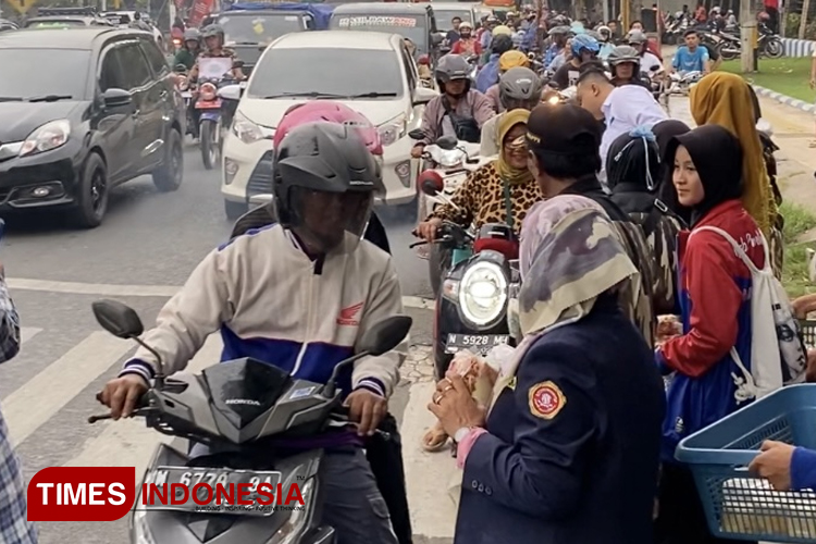 Karang Taruna membagikan takjil pada pengguna jalan. (Foto: Abdul Jalil/TIMES Indonesia)